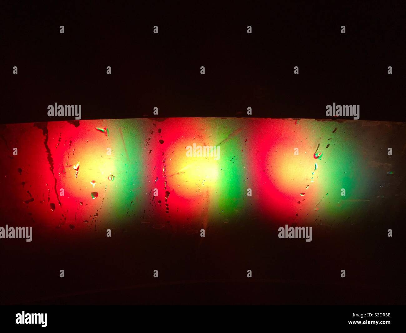 Colorful lights on black background with water drops on them. Variations of Red, yellow and green  bright colours. - Smartphone Captured Stock Image