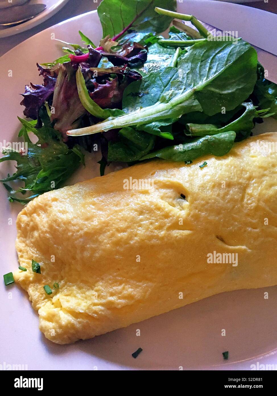 Close-up of a fluffy omelette and salad, brunch at a French bistro, NYC, USA - Smartphone Captured Stock Image