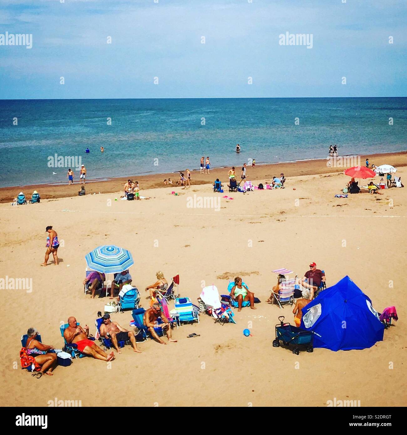 Brackley Beach in Prince Edward Island on a summer day with crowds of people sunbathing and swimming - Smartphone Captured Stock Image