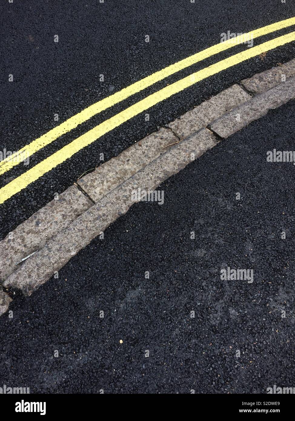 Yellow lines and path curb Stock Photo Alamy