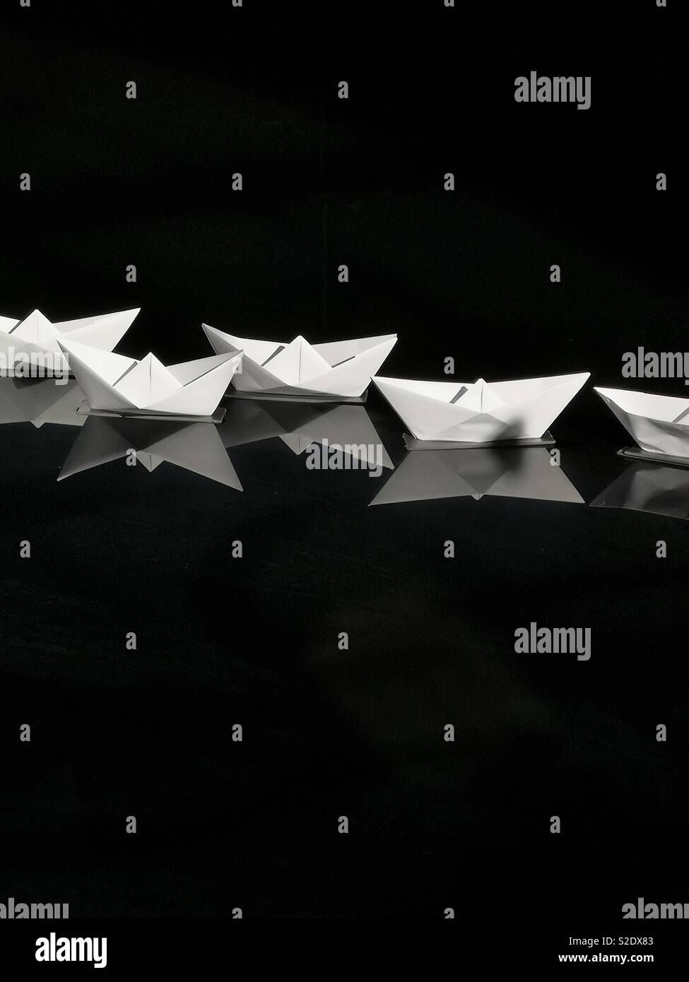 Paper boats in a cistern art piece Stock Photo