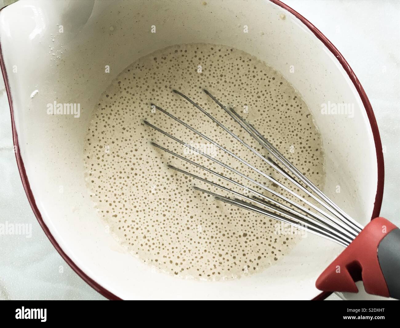 Pancake batter mixture in a ceramic jug with a whisk Stock Photo Alamy