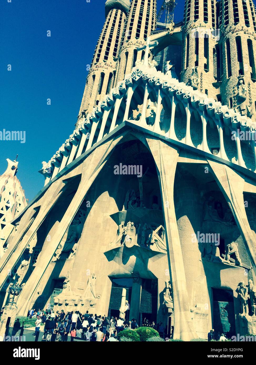 Portrait of Sagrada Familia Basilica with queuing tourists waiting to get inside in Barcelona Spain Stock Photo