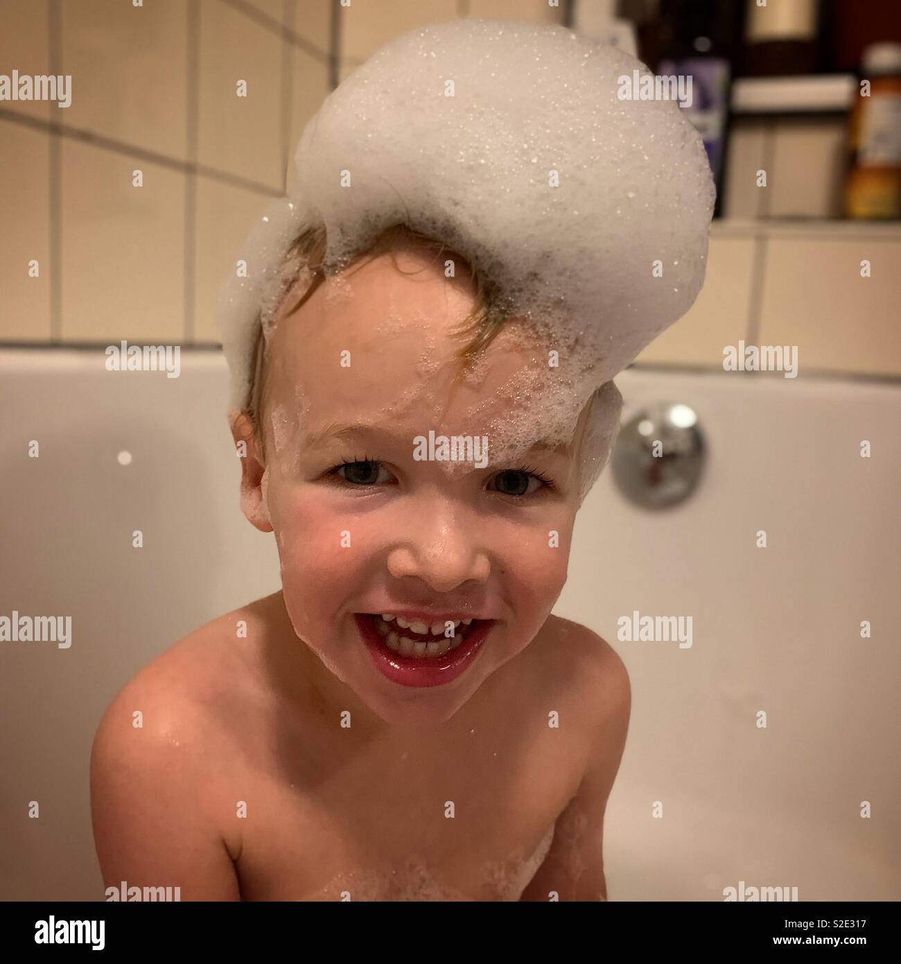 Toddler with bubbles on head in bath Stock Photo Alamy