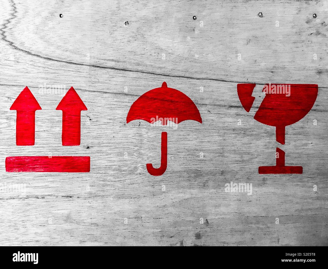 Packing symbols with keep dry,fragile and this way up on a wooden crate with selective colour Stock Photo