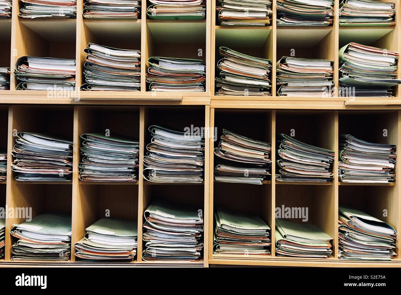 Stacks of documents lying in a shelf of an office. Stock Photo