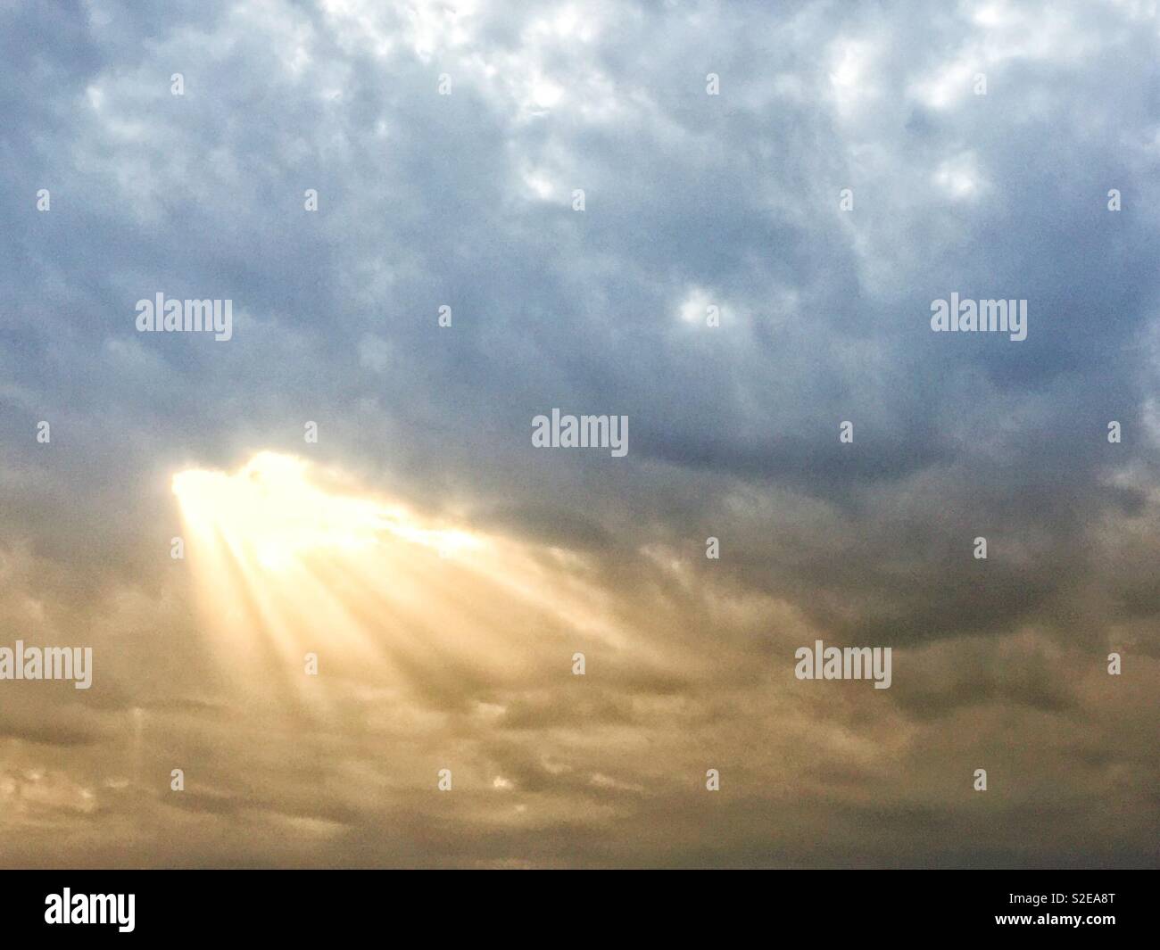 Sun beams peeking through dense clouds - Smartphone Captured Stock Image Sun beams peeking through dense clouds - Smartphone Captured Stock Image