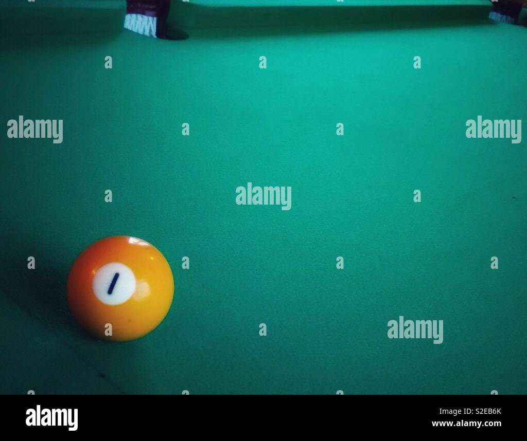 Number 1 pool ball. Green baize pool table copy space. - Smartphone Captured Stock Image
