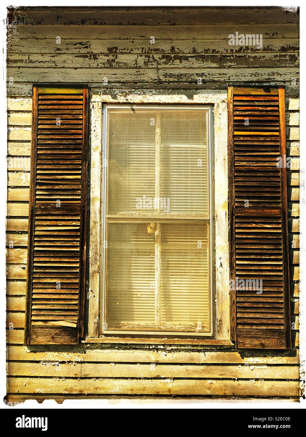 Weathered shutters on a weathered home Stock Photo