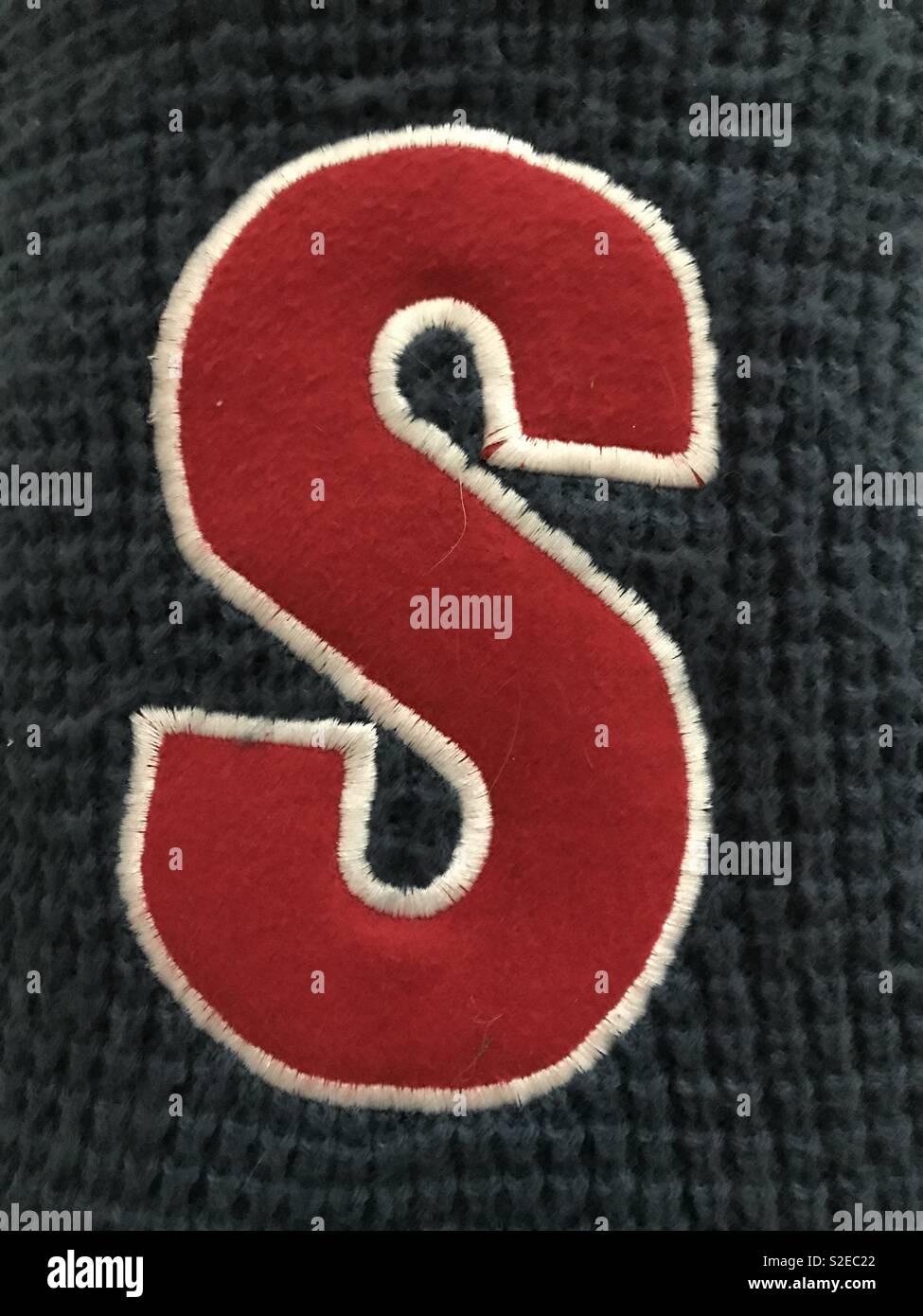 Red letter S on a blue wooden scarf Stock Photo
