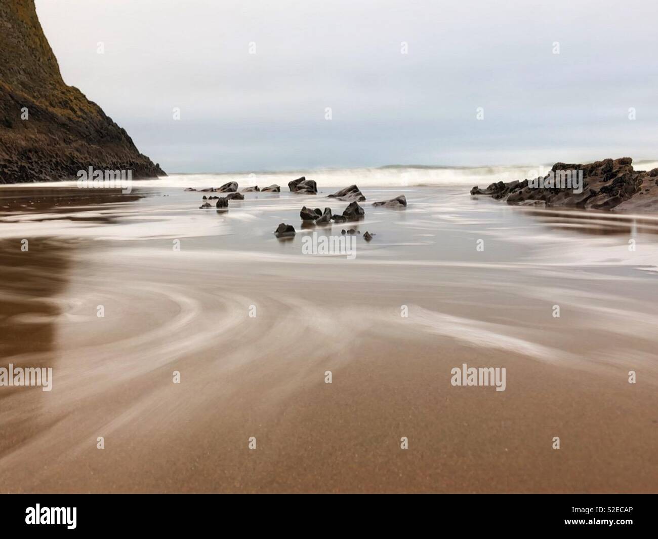 Waves surging up a Welsh beach, early morning, November. Stock Photo