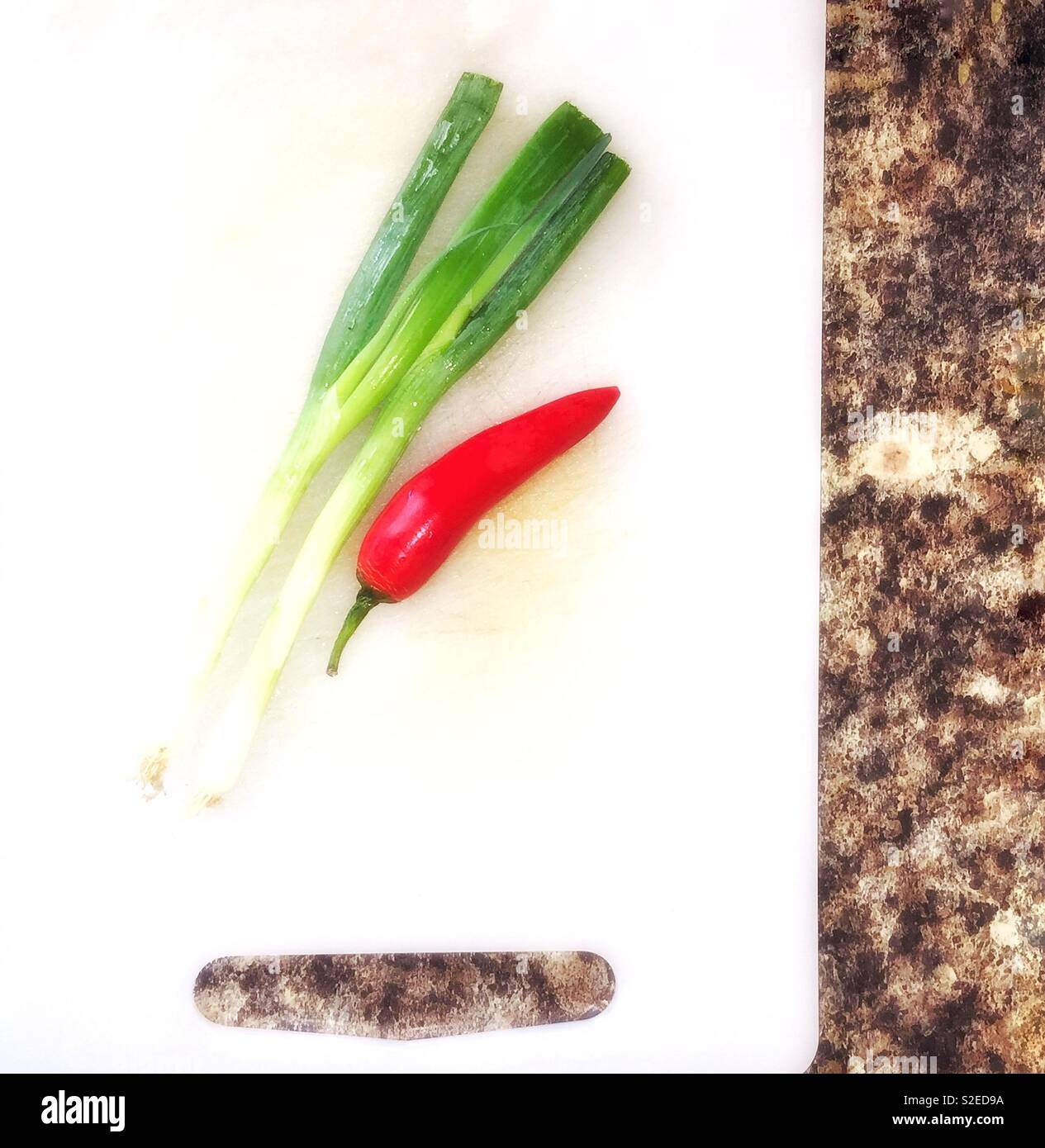 Red chilli and spring onions on a chopping  board. - Smartphone Captured Stock Image Red chilli and spring onions on a chopping  board. - Smartphone Captured Stock Image