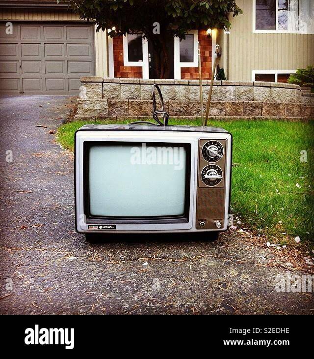 Old vintage TV with dials and antenna. On a driveway for junk pickup Stock  Photo - Alamy