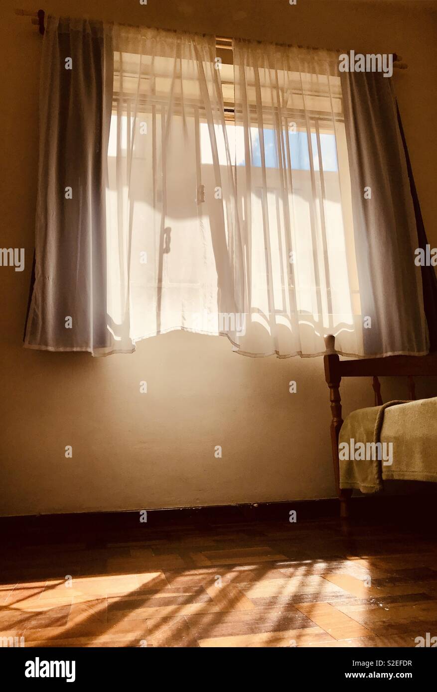 Large window with sunlight and curtain moving in the wind Stock Photo