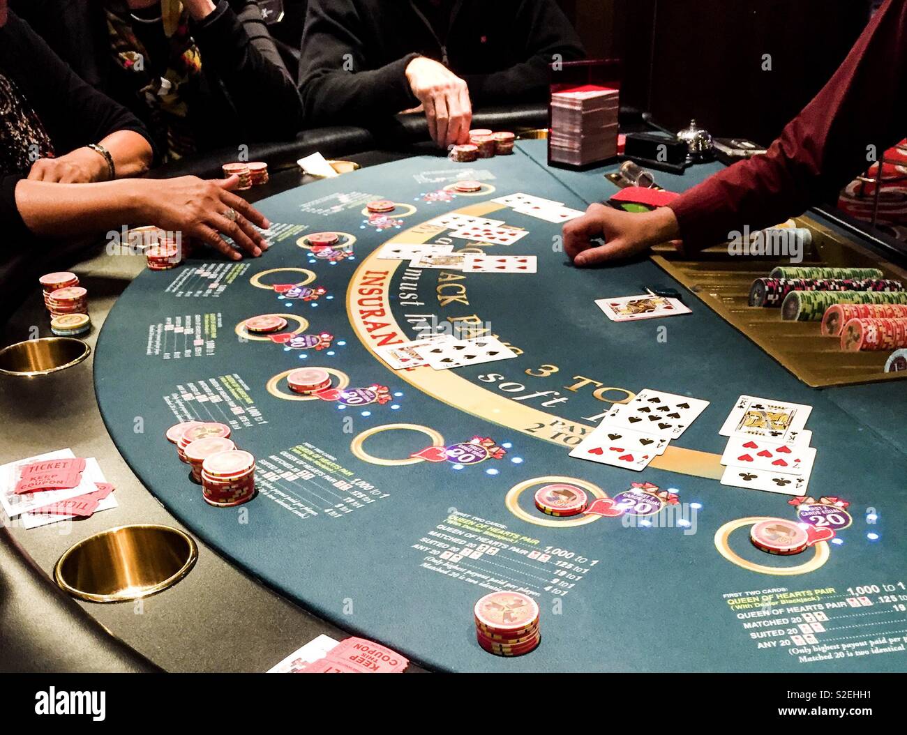 People playing poker at a casino. Dealer waits for players to place bets during a game of the card game poker. Stock Photo