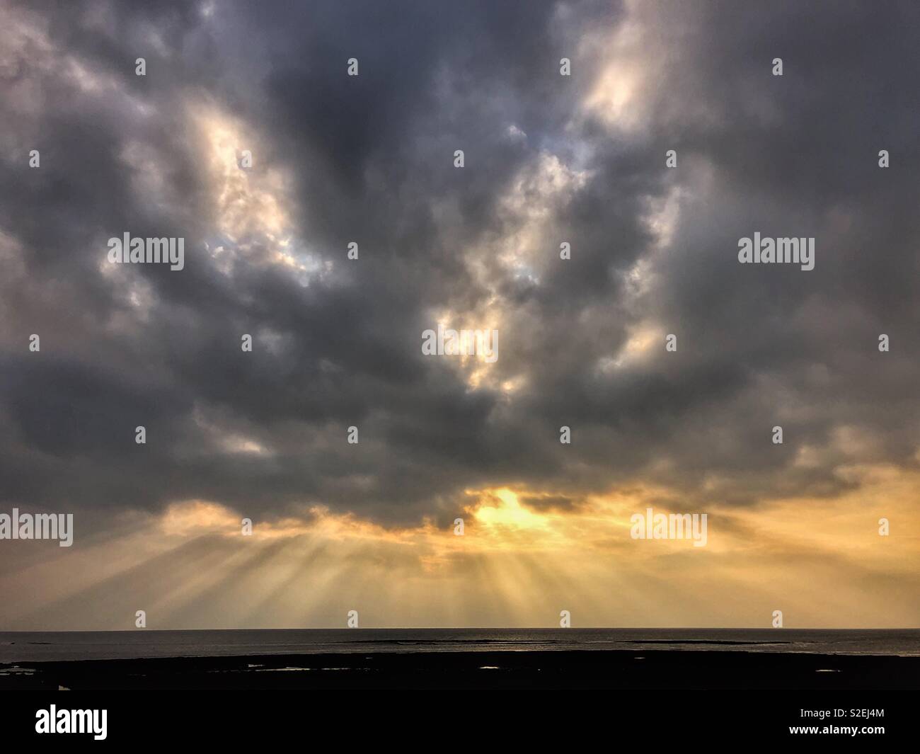 Dramatic evening sky with crepuscular rays over the Bristol Channel, Wales, November. - Smartphone Captured Stock Image Dramatic evening sky with crepuscular rays over the Bristol Channel, Wales, November. - Smartphone Captured Stock Image