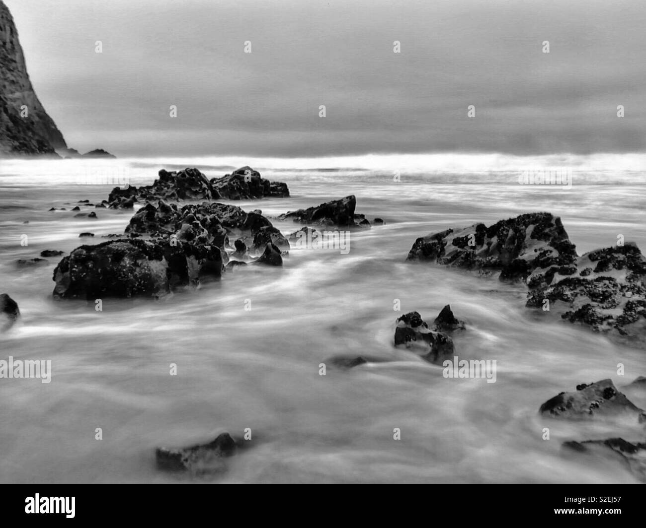 Incoming tide washing around rocks on the Gower coast, Wales, November. Stock Photo