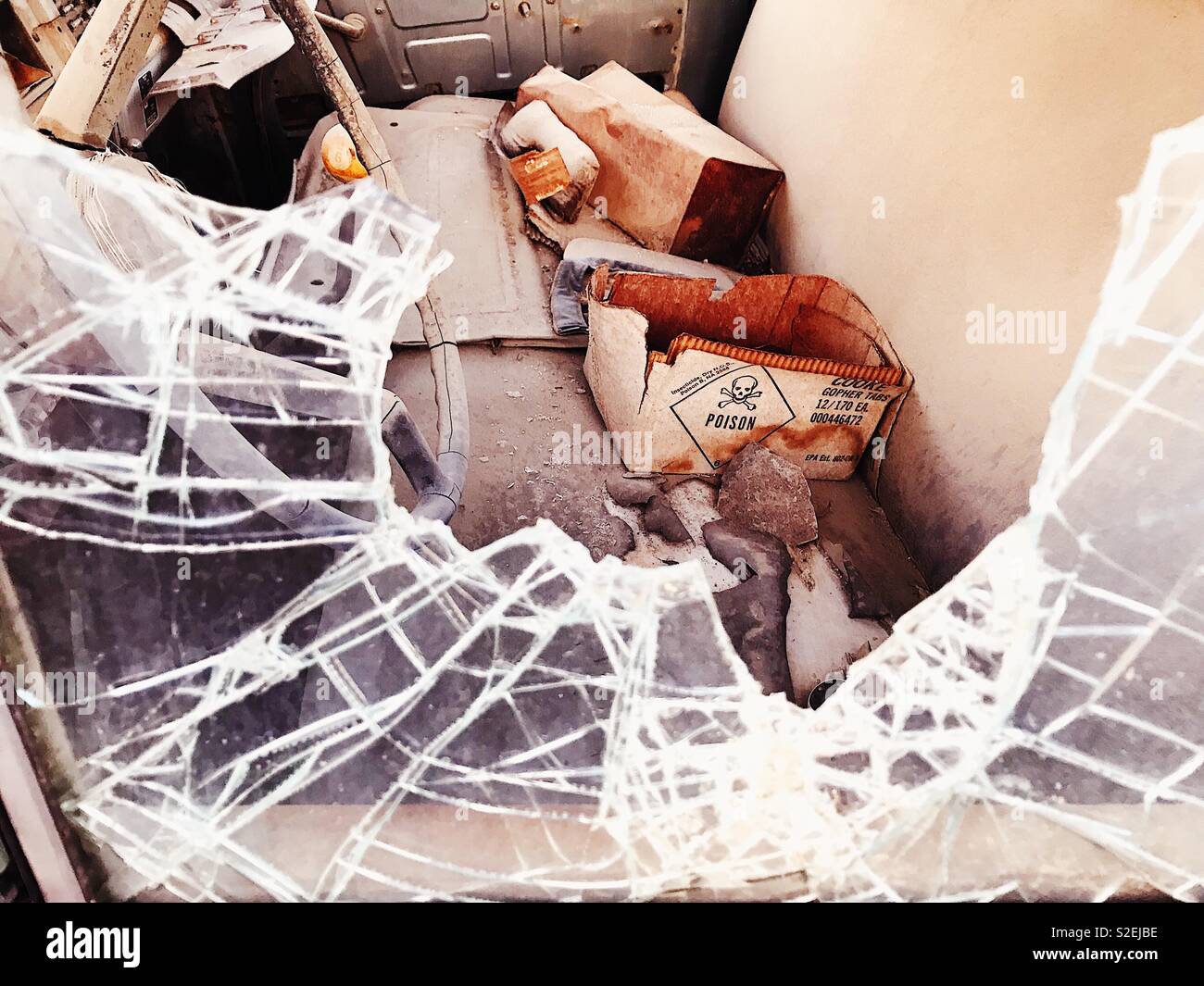 Poisoned Van. Abandoned van in a ghost town. Shattered glass and debris, packs of insecticide. Ballarat, CA, USA. 2017 - Smartphone Captured Stock Image