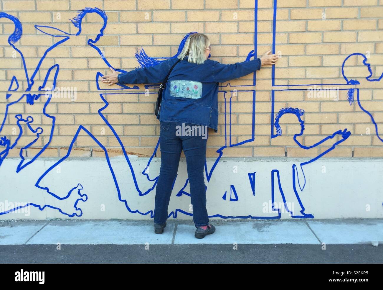 Woman against wall covered with figures made with tape - Smartphone Captured Stock Image