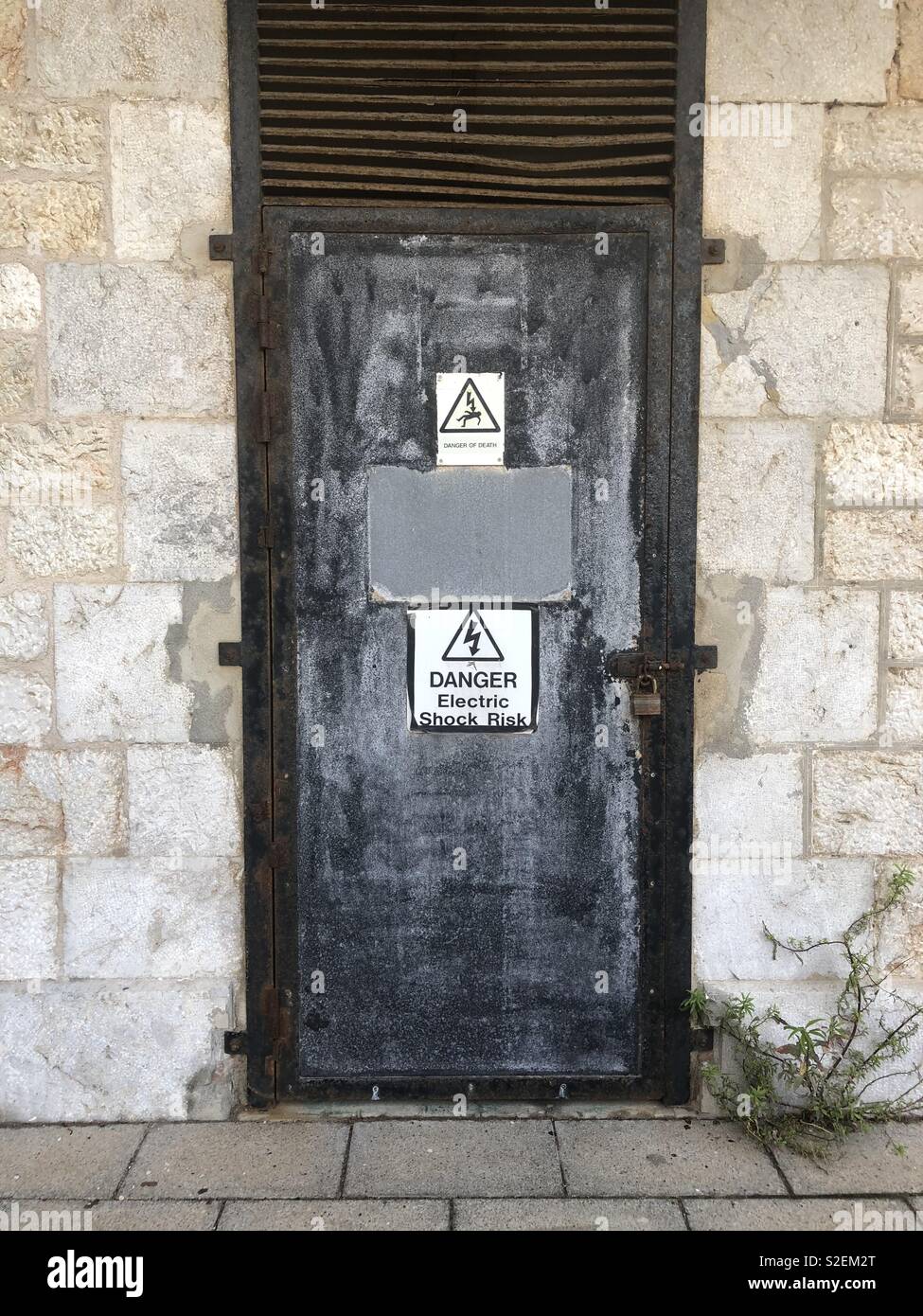 Old door with faded danger of death signs - Smartphone Captured Stock Image