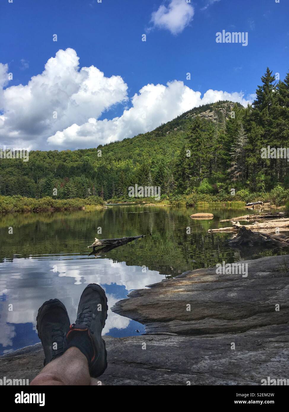 Hiker’s Feet with boots in Adirondack Mountains by lake, New York, NY, USA Stock Photo