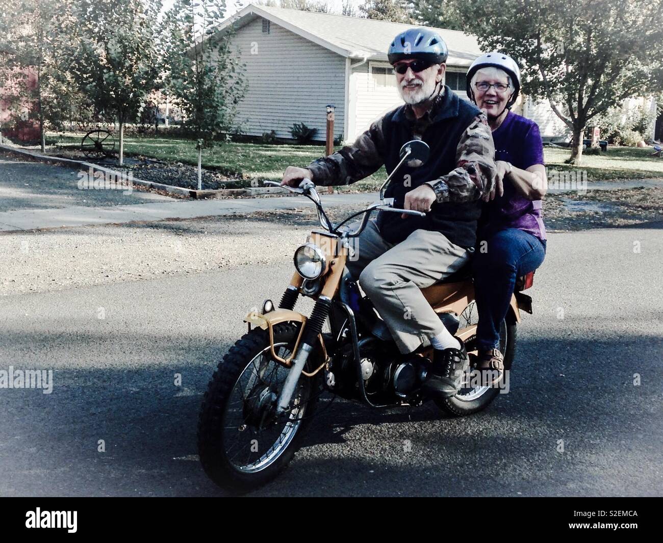Muted photo of senior couple on a dirt bike - Smartphone Captured Stock Image