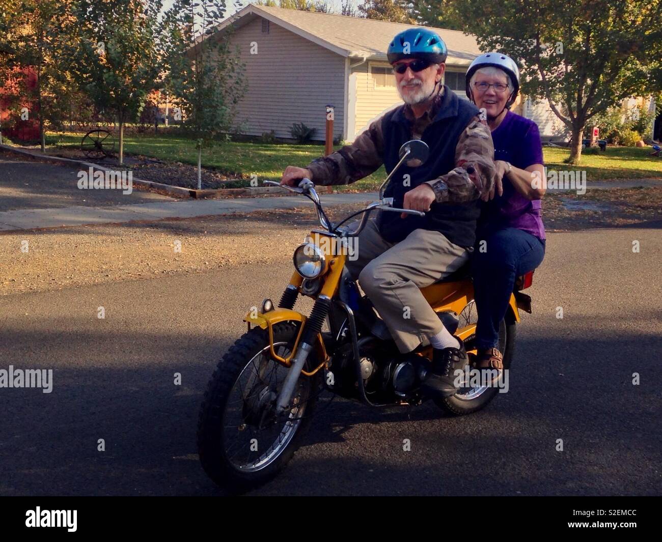 Bright photo of senior married couple on a dirt bike - Smartphone Captured Stock Image
