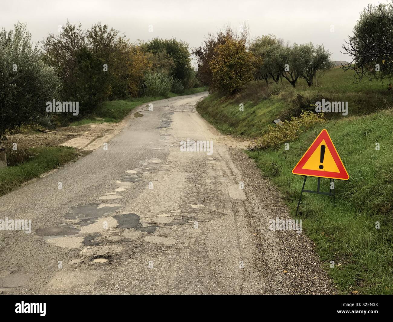 Rough road with street sign Stock Photo