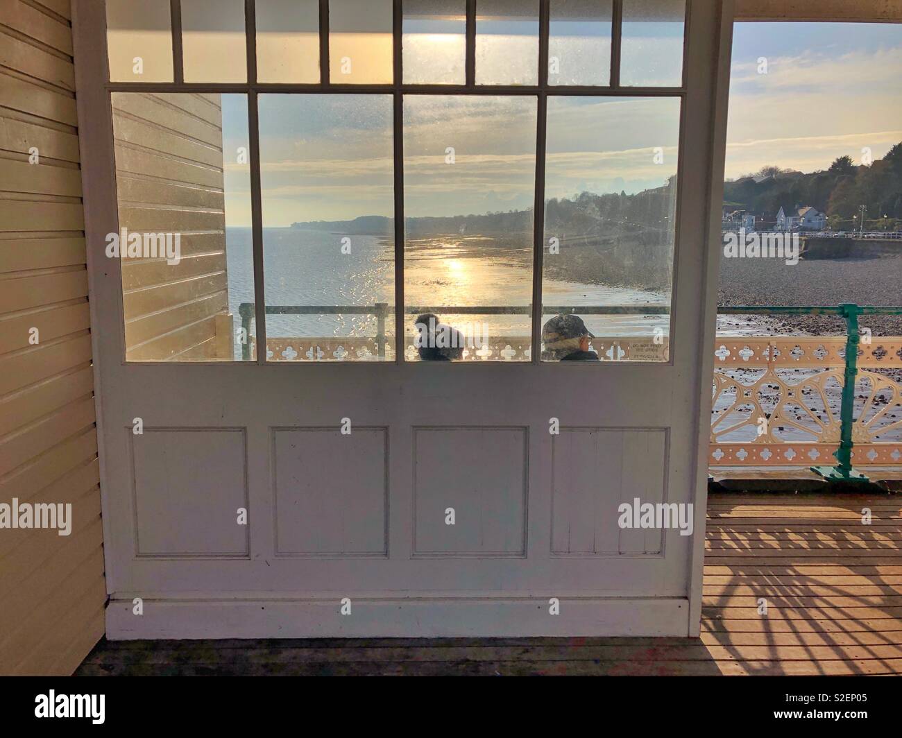 Two elderly people enjoying the view on a Welsh pier, November. - Smartphone Captured Stock Image