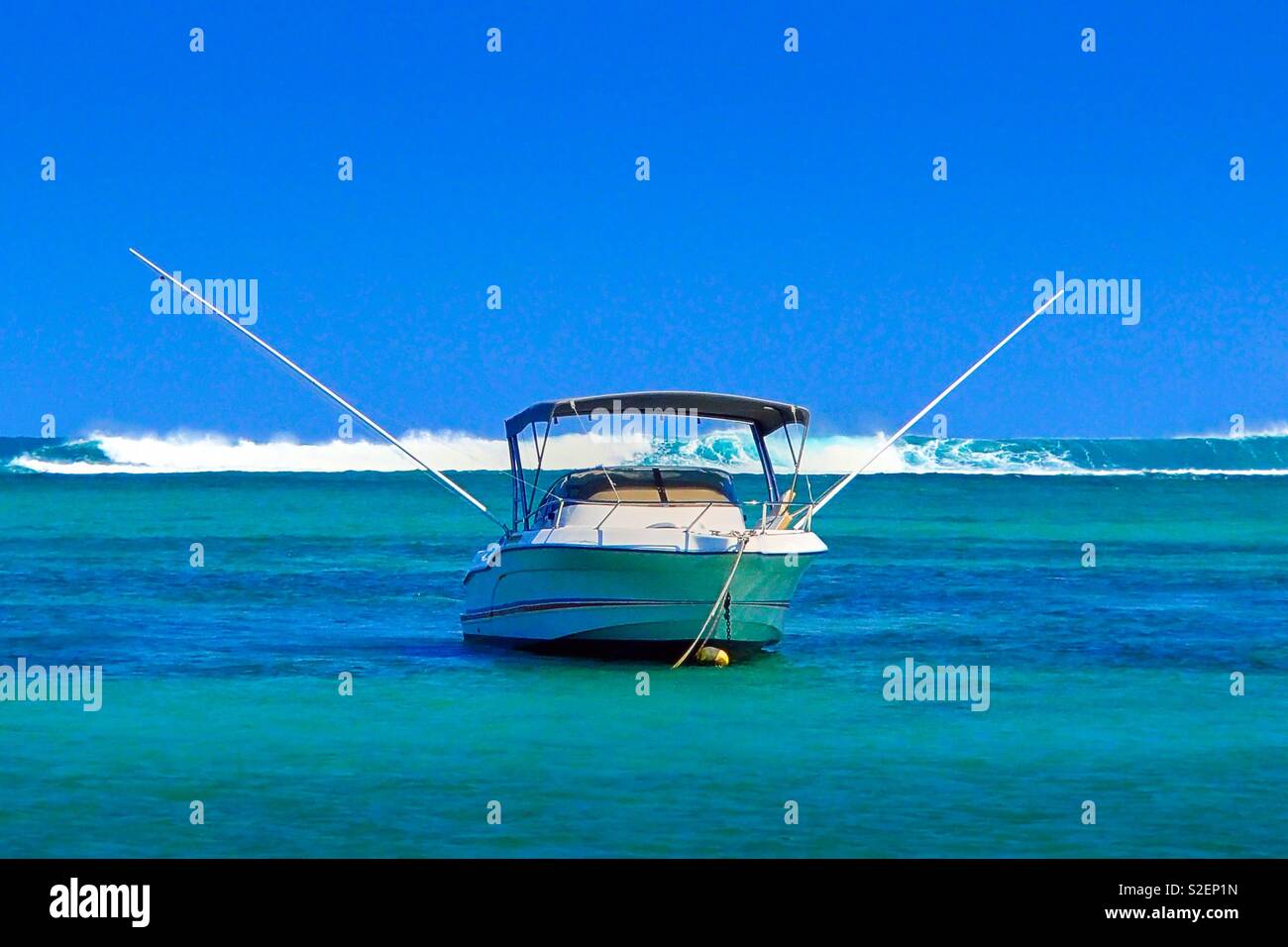 A Deep Sea Fishing Boat Anchors In The Turquoise Water Off A Deep Sea Fishing Boat Anchors In The Turquoise Water Off