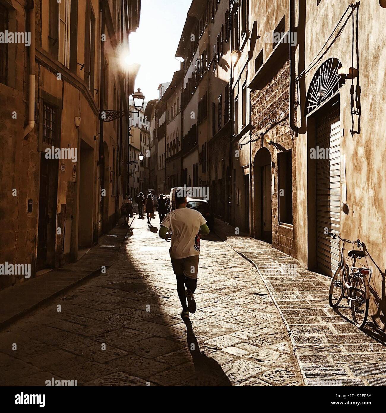 Runner on a Street of Florence. An amateur athlete is training in the historical center of Florence one day before half-marathon competition. Florence, Tuscany, Italy. 8th of April 2017. - Smartphone Captured Stock Image