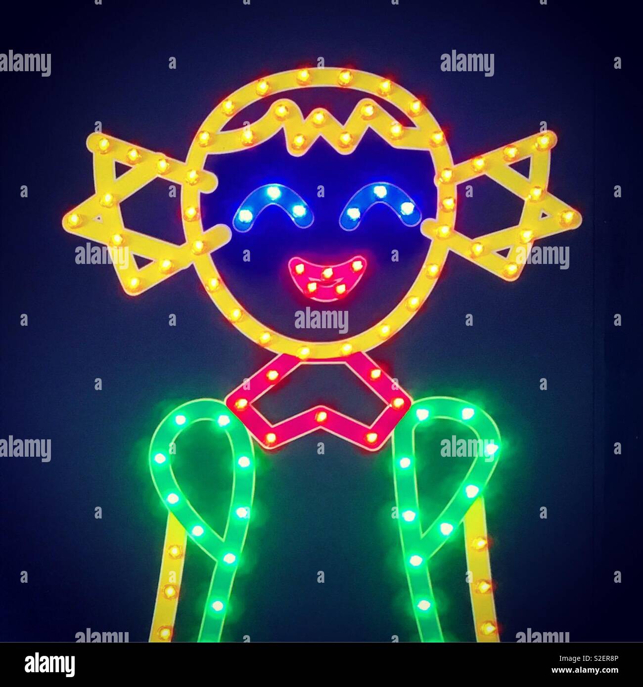 Smiling girl done with glowing neon garlands bulbs Stock Photo
