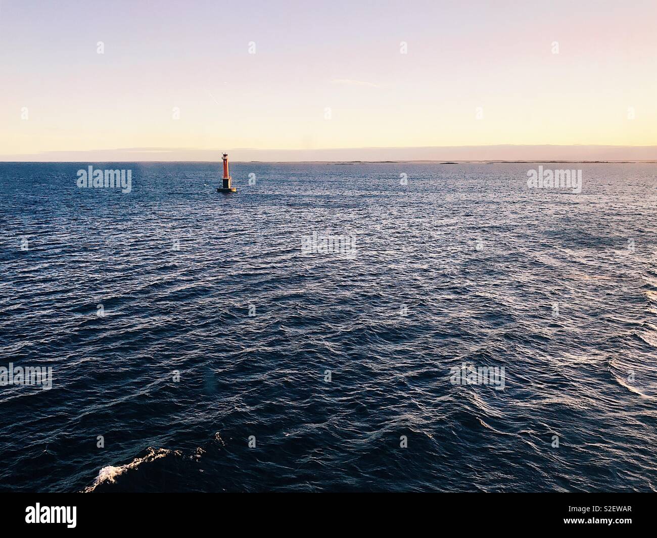 Does the Lighthouse Dream About Open Sea? A lighthouse near the shores of Sweden. View from a ferry. Värmdö - Sandhamn, Stockholm Archipelago, Sweden. 6th of May 2017 - Smartphone Captured Stock Image