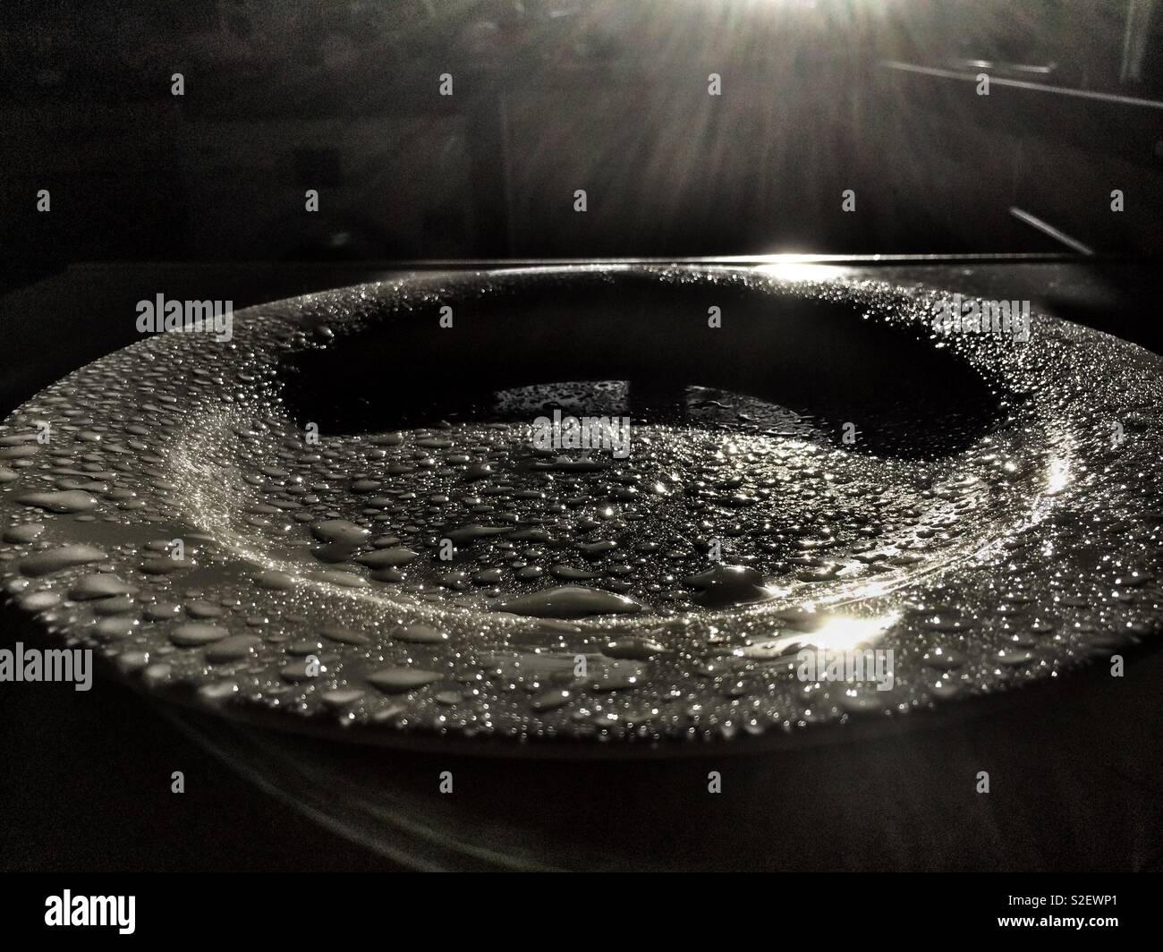 Close-up of plate in the kitchen with drops of water,illuminated by sunshine light - Smartphone Captured Stock Image