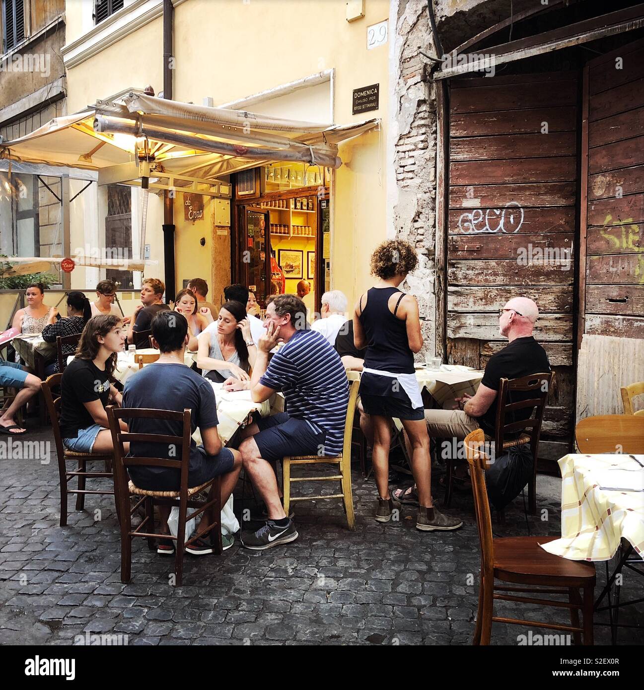Dining outside at Trattoria Da Enzo, Trastevere, Rome. - Smartphone Captured Stock Image