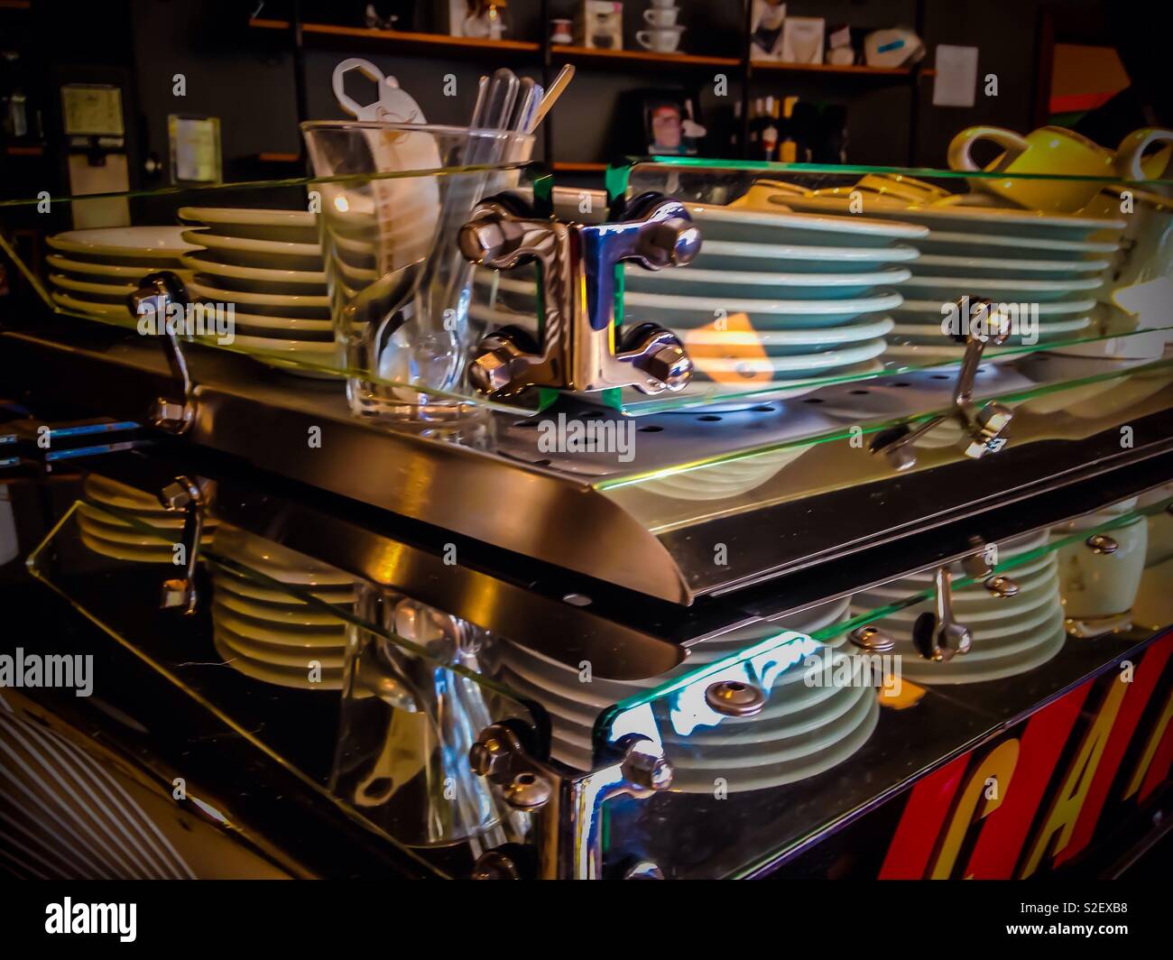 Landscape oriented photo of steel and glass shelf containing white dishware in a Seattle coffeeshop - Smartphone Captured Stock Image