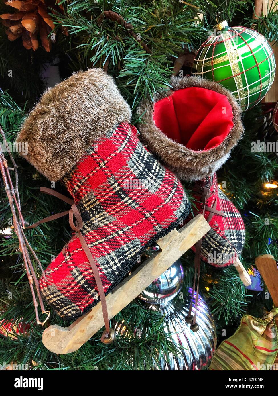 Plaid skates decorate a Christmas tree. - Smartphone Captured Stock Image
