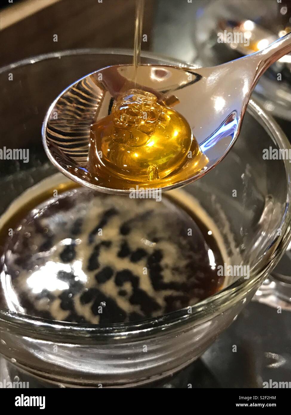 Pouring honey on spoon for sweeteningt he coffee. - Smartphone Captured Stock Image