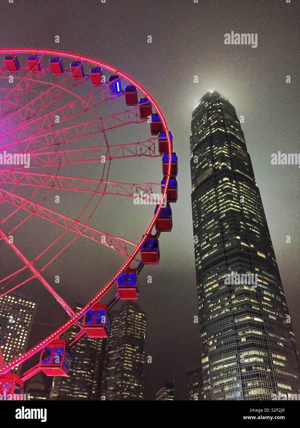 The Hong Kong Observation Wheel at the Central waterfront at night, with 2ifc, Hong Kong Island's tallest skyscraper - Smartphone Captured Stock Image