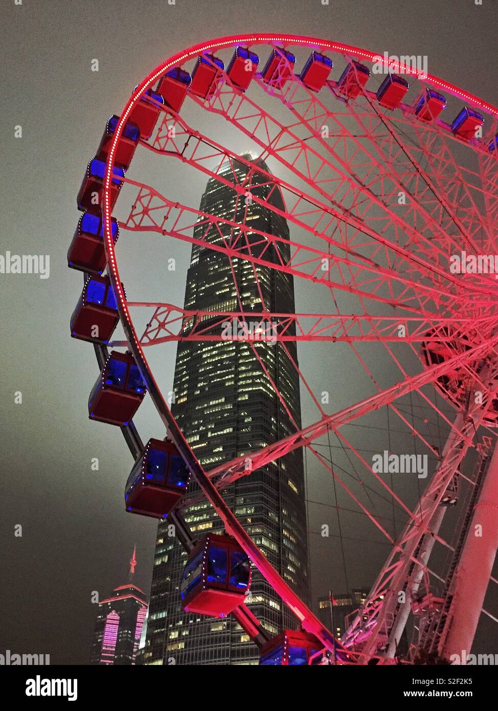 The Hong Kong Observation Wheel at the Central waterfront at night, with 2ifc, Hong Kong Island's tallest skyscraper - Smartphone Captured Stock Image