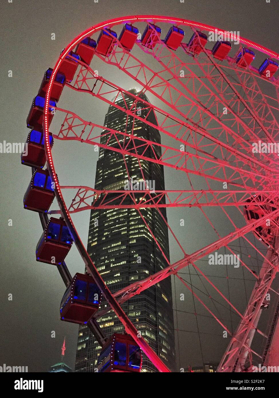 The Hong Kong Observation Wheel at the Central waterfront at night, with 2ifc, Hong Kong Island's tallest skyscraper - Smartphone Captured Stock Image