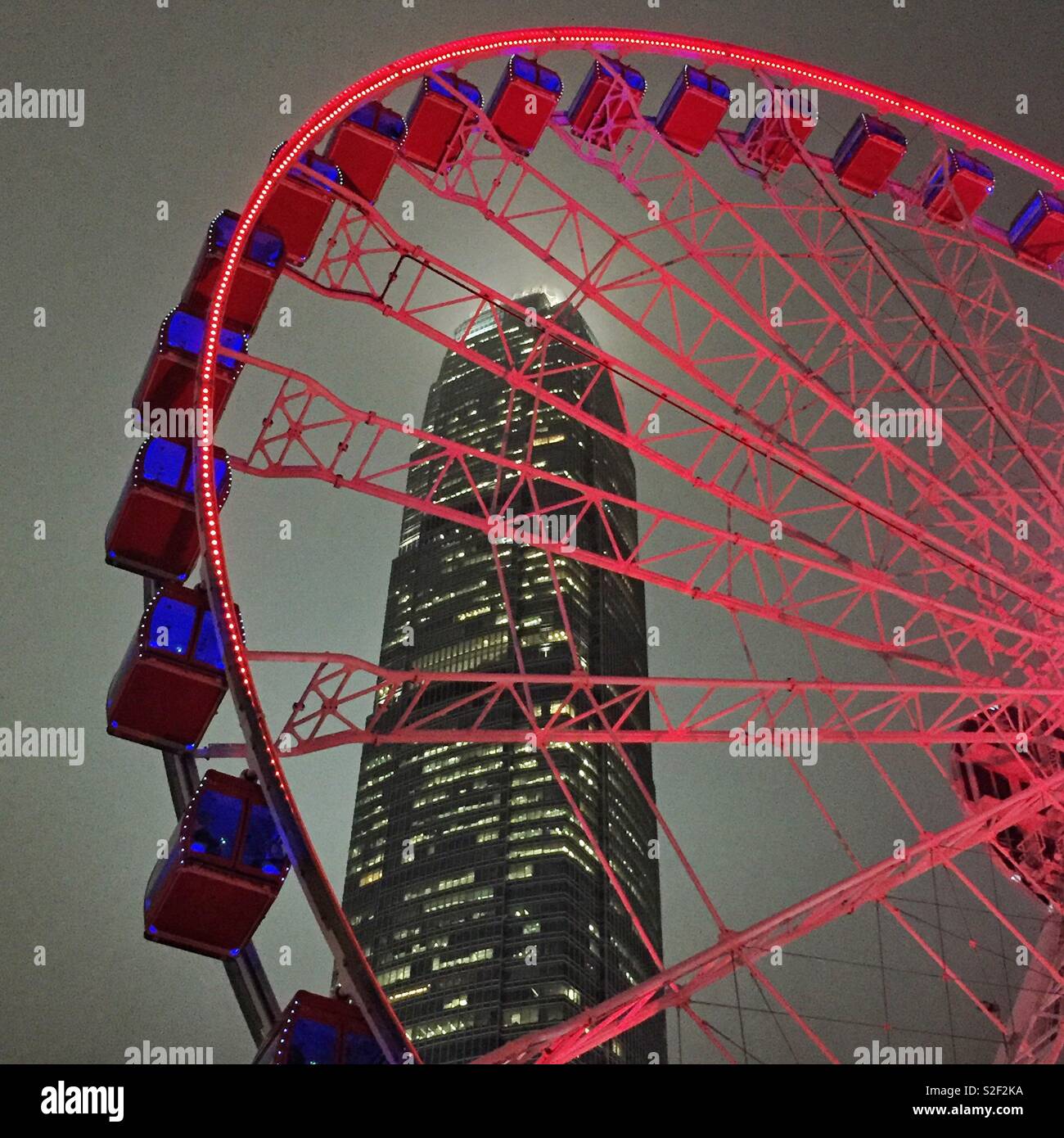 The Hong Kong Observation Wheel at the Central waterfront at night, with 2ifc, Hong Kong Island's tallest skyscraper - Smartphone Captured Stock Image