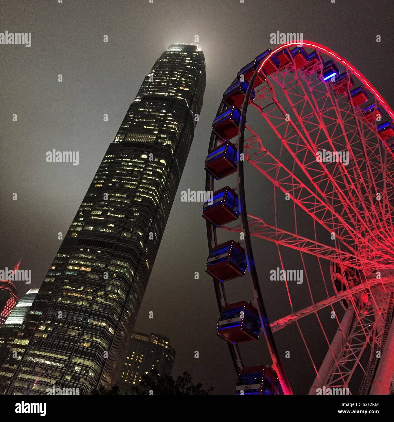 The Hong Kong Observation Wheel at the Central waterfront at night, with 2ifc, Hong Kong Island's tallest skyscraper - Smartphone Captured Stock Image