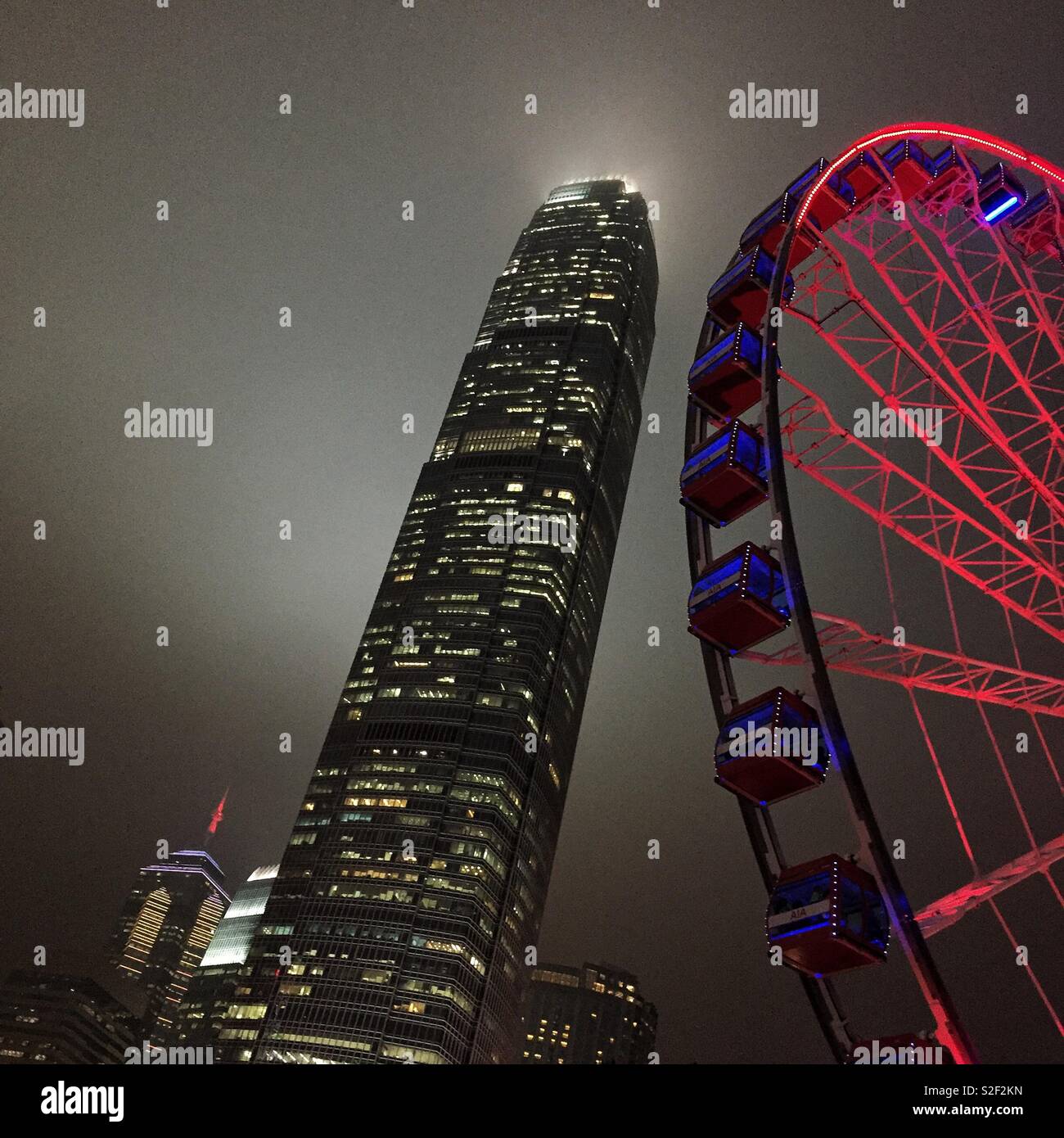 The Hong Kong Observation Wheel at the Central waterfront at night, with 2ifc, Hong Kong Island's tallest skyscraper - Smartphone Captured Stock Image