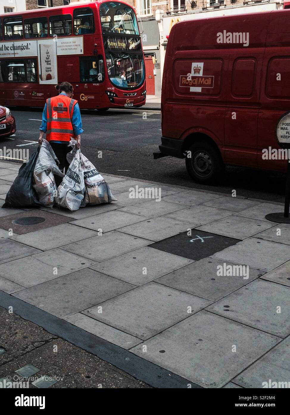 Royal Mail employee pulling bags with letters to a company van. Baker Street, London, UK. - Smartphone Captured Stock Image