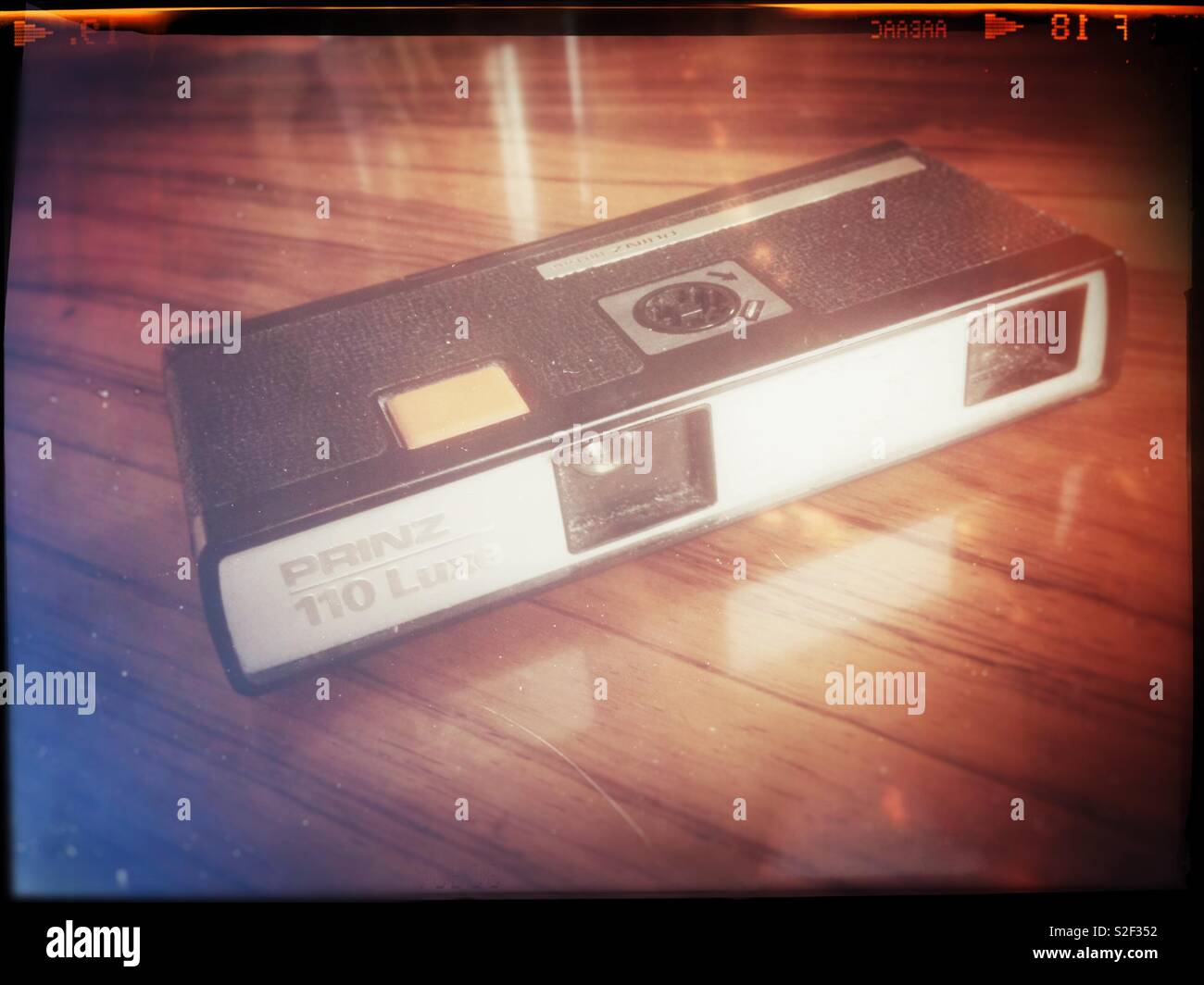 A vintage pocket camera from ca 1972 in the redundant 110 film format on a mahogany table. Retro treatment. - Smartphone Captured Stock Image