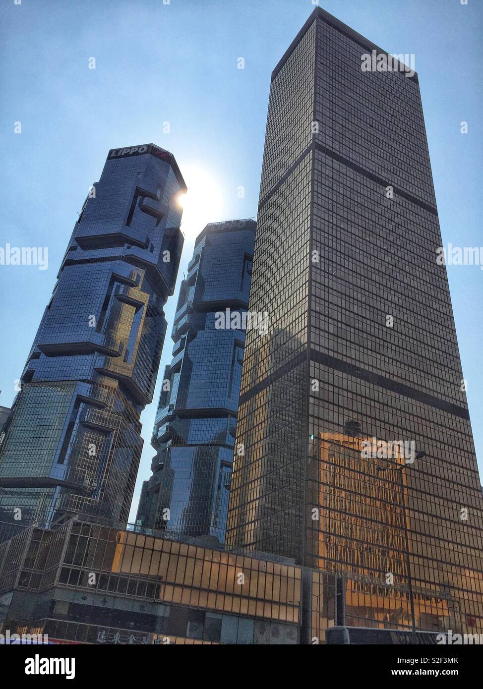 The twin towers of the Lippo Centre and the golden Far East Finance Centre, known colloquially as 'The Amah's Tooth', in Admiralty, Central, Hong Kong Island - Smartphone Captured Stock Image