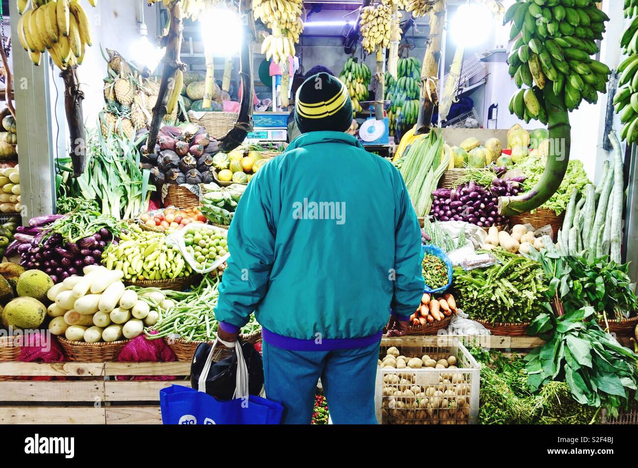 Single man standing in front of a market stand with fresh fruits and vegetables Stock Photo Alamy