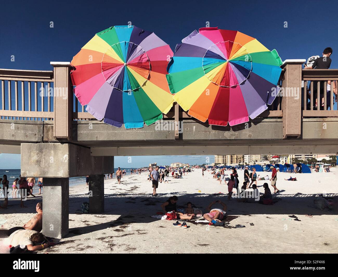 Rainbow colored umbrellas decorate  Pier 60 boardwalk on Clearwater beach in Florida - Smartphone Captured Stock Image
