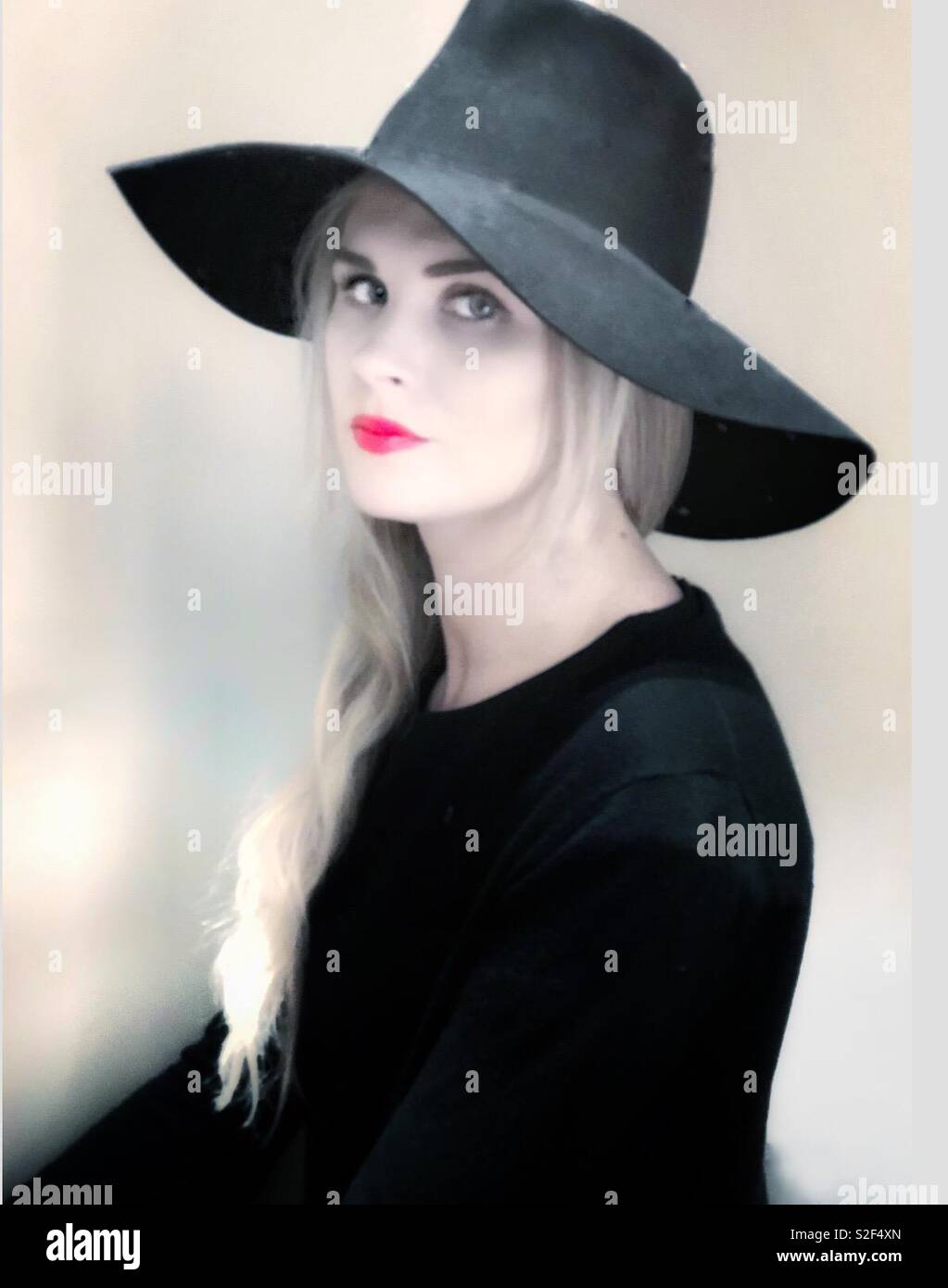 A young blonde woman dressed in black gazed at the camera. - Smartphone Captured Stock Image